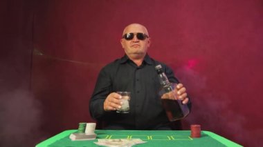 Riskli bir poker oyuncusu iskambil oynarken viski döker.