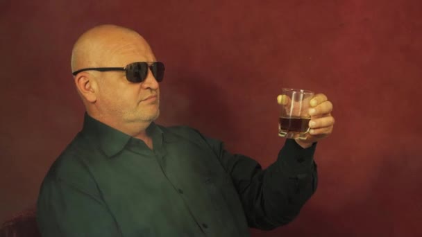 En riskfylld spelare under spelet håller och undersöker ett glas whisky närbild. — Stockvideo