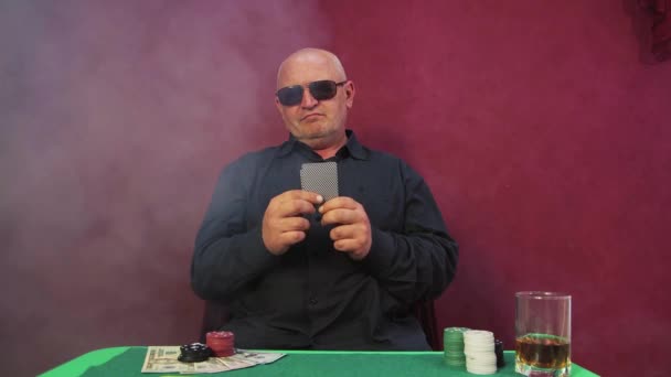 Ο ριψοκίνδυνος τζογαδόρος στο καζίνο κοιτάζει και διπλώνει τα χαρτιά του. — Αρχείο Βίντεο