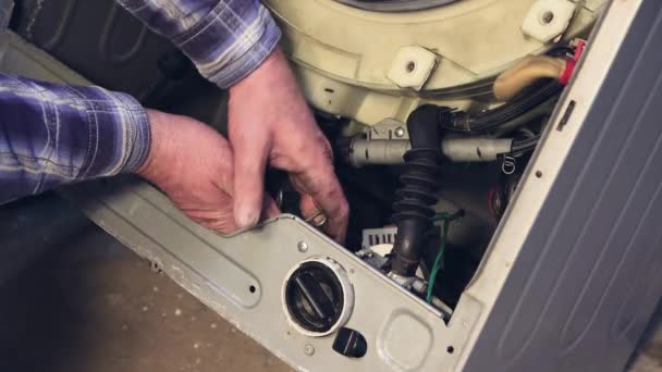 The hands of the foreman disconnect the tubes inside the washing machine. — Stock Video