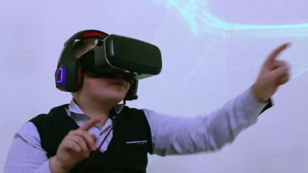 Un chico con gafas de realidad aumentada presiona botones virtuales con los dedos. — Vídeos de Stock