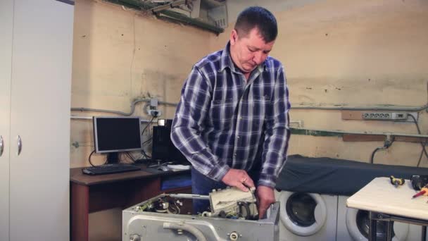 O homem desliga a parte da máquina de lavar roupa. — Vídeo de Stock