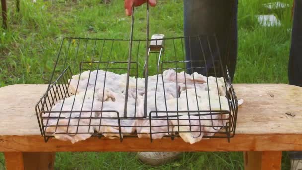 Una mano di mans chiude la griglia con grandi pezzi di carne barbecue. — Video Stock