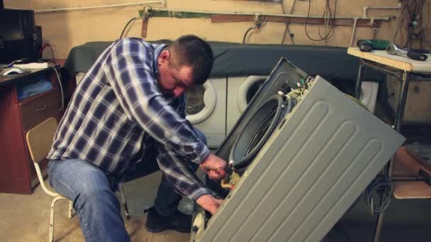 The master assembles the washing machine, tightens the bolts — Stock Video