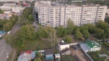 Yüksek binası ve küçük binaları olan bir şehir caddesinin kuş bakışı görüntüsü..