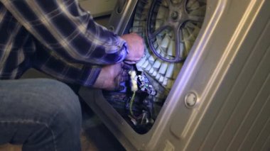 Sanatçı çamaşır makinesindeki kabloları güçlendirir.. 