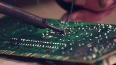 Elektronik devre kartını tamir eden lehim demiri yakın plan..