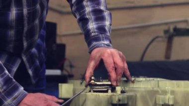 Ustanın elleri eski ısıtma elementini davuldan çıkarır.. 