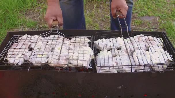 Le mani maschili stanno posando setacci con carne marinata sulla griglia. — Video Stock