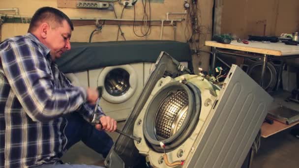 The technician bolts the new part into the washing machine. — Stock Video