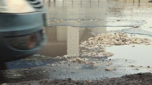 Büyük çukurlar, yağmurdan sonra hasar gören yol altyapısı. — Stok video