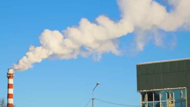 Ciel bleu et fumée blanche de la cheminée passe sur le toit de la maison. — Video