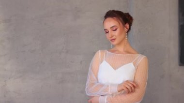 Beyaz elbiseli bir kız fotoğrafçı için profesyonel poz veriyor..