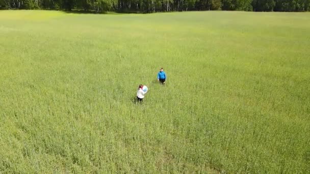 Um menino e uma menina estão jogando uma bola no campo, câmera lenta. — Vídeo de Stock