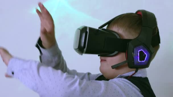 Ein Junge in einem Augmented-Reality-Headset im Profil bewegt seine Arme — Stockvideo