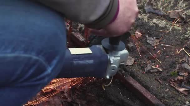 Mans hands are cutting the old, destroyed metal structure with a grinder. — ストック動画