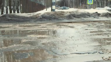 Asfalttaki çukurlar, yağış sonrası hasar gören yol altyapısı.