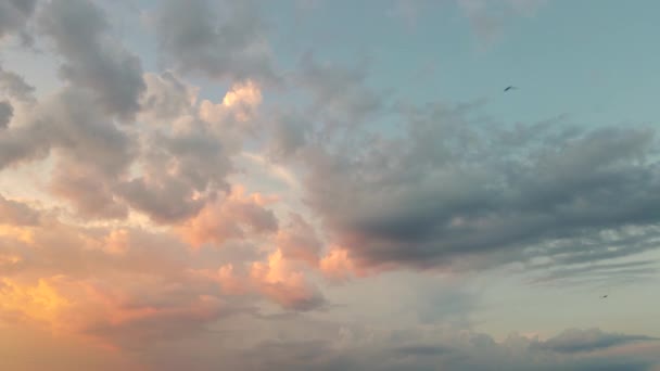Belle nuvole arancioni si muovono alla luce del sole contro il cielo blu. — Video Stock