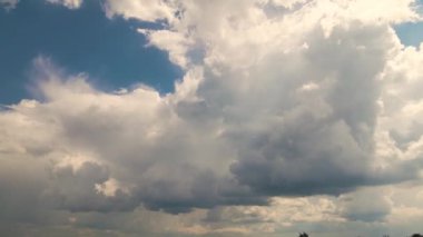 Mavi gökyüzüne doğru süzülen bulutlarla güzel bir manzara..