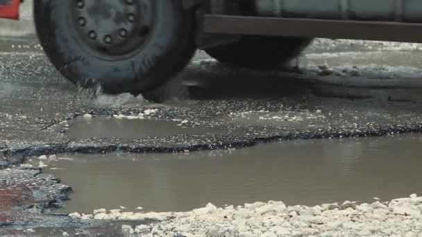 Asfalttaki çukurlar, yağmurdan sonra hasar gören yol altyapısı. — Stok video