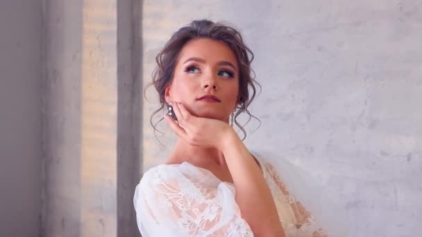 Das Mädchen im weißen Kleid posiert für den Fotografen, der sich wunderschön dreht. — Stockvideo