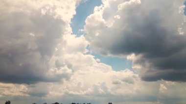 Mavi gökyüzüne karşı gün ışığında süzülen bulutlarla panorama. 