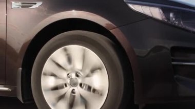 Geçen bir arabanın yanında dönen bir tekerlek.. 