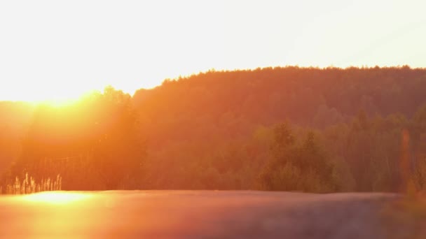 Автомобиль выезжает с горизонта на фоне вечернего солнца. — стоковое видео