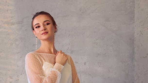 A young girl in a white dress poses professionally for a photographer — Stock Video
