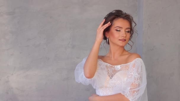 Jovem encantadora em um vestido branco posando lindamente. — Vídeo de Stock