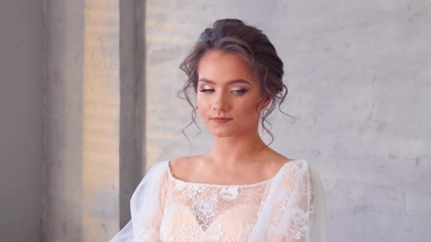 Young pretty model girl posing in a white dress close-up. — Stock videók