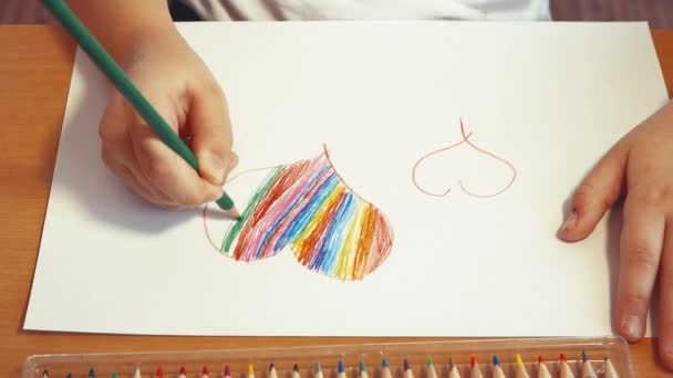 Kinderhände malen das Herz in Regenbogenfarben. — Stockvideo