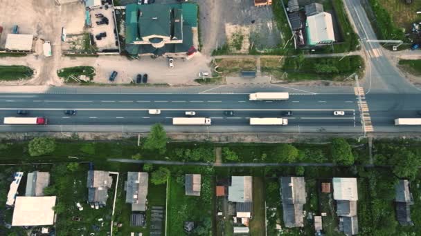 Camions et voitures passent une intersection suburbaine, vue aérienne. — Video