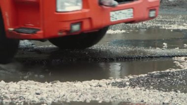 Yağmurdan sonra çok derin çukurlar, kötü hasar görmüş yol altyapısı. 