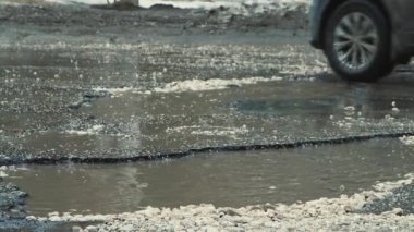 Kötü havada suyla dolu büyük çukurlar, kötü hasar görmüş yol altyapısı.. 