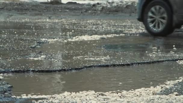 Große Gruben mit Wasser bei schlechtem Wetter, stark beschädigte Straßeninfrastruktur. — Stockvideo