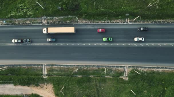 Coches conducen a lo largo de una pequeña carretera, vista de aves. — Vídeos de Stock