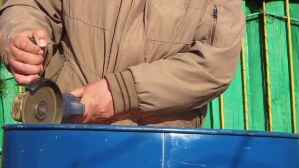 Крупный план руки человека с помощью шлифовального станка, чтобы вырезать дно из бочки. — стоковое видео