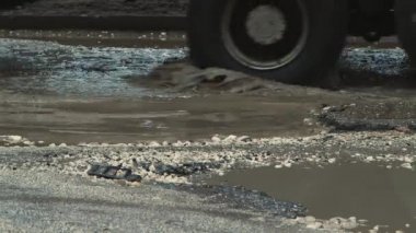 Kötü havada suyla dolu tehlikeli çukurlar, kötü hasar görmüş yol altyapısı..