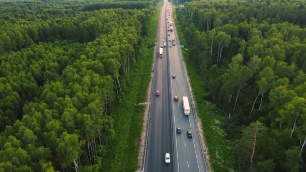 Camions et voitures roulent sur l'autoroute dans des directions opposées, vue aérienne. — Video