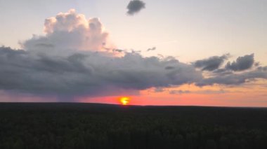 Güneşin ufukta göründüğü güzel, kırmızı bir gökyüzünün manzarası..