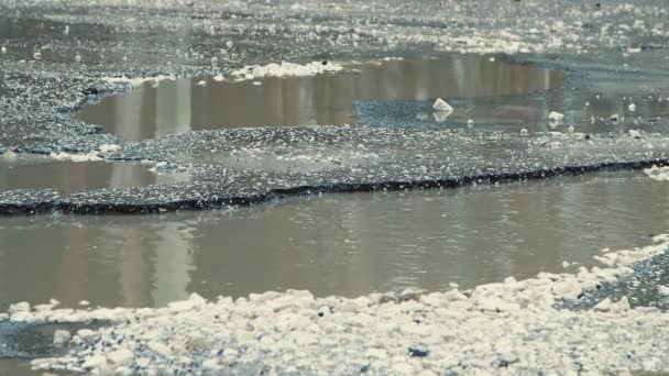 Enorme kuilen na regen, zwaar beschadigde wegeninfrastructuur. — Stockvideo