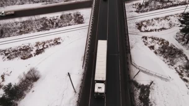 Velký, dlouhý nákladní automobil jede v zimě po dvouproudové dálnici, letecký výhled. — Stock video