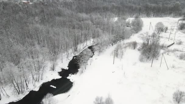 Vánoční fantastická zasněžená krajina s nemrznoucí řekou, letecký pohled. — Stock video