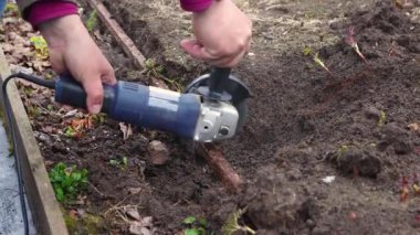 Açı öğütücüsü olan eller eski, paslı metalleri kesiyor..