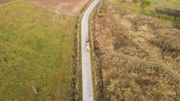 No caminho, um trator carregado com fardos de feno, vista aérea. — Vídeo de Stock