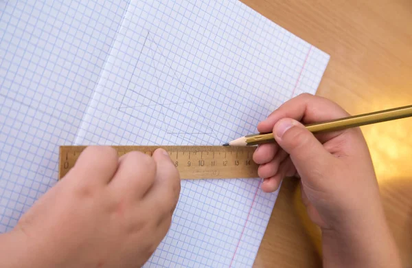 Студент малює трикутник олівцем уздовж лінійки . — стокове фото