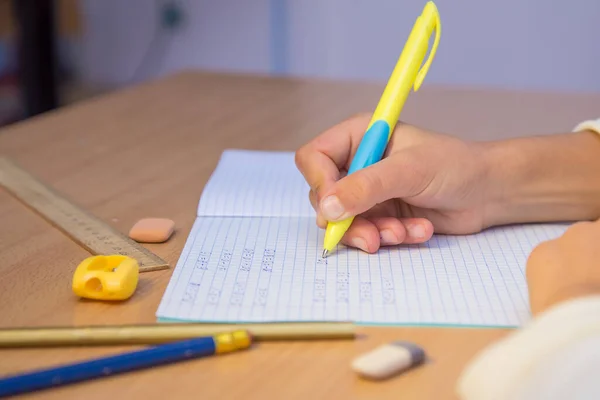 Рука учнів пише з кульковою ручкою в блокноті крупним планом . — стокове фото