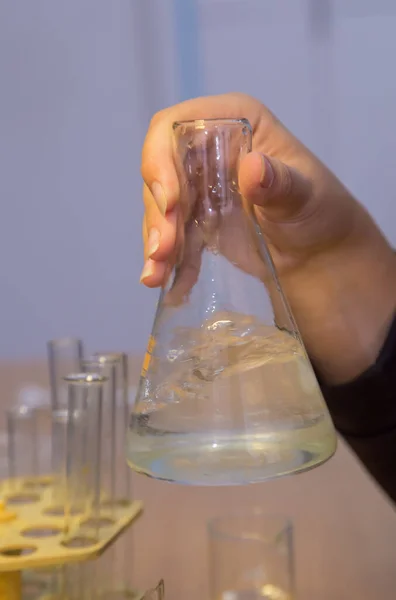 Göz bebeklerinin elleri kimyasal çözeltisi olan bir şişeyi sallıyor..