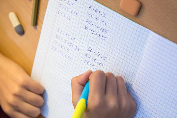 Крупним планом руки учнів вирішує математичні приклади в блокноті . — стокове фото